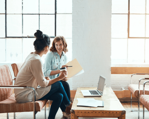 two people sitting at the coffee table and working on hr and payroll solutions for small business in Nevada
