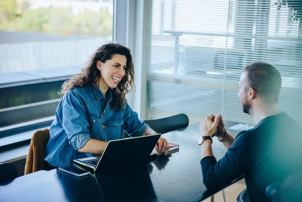 A diverse group of business professionals discusses HR solutions and services for Nevada businesses in a modern office.
